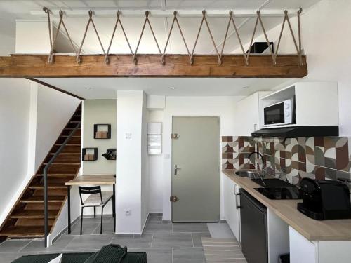 une chambre avec une cuisine avec un escalier et une cuisine avec une table dans l'établissement AbriZen Toulouse Hypercentre, à Toulouse