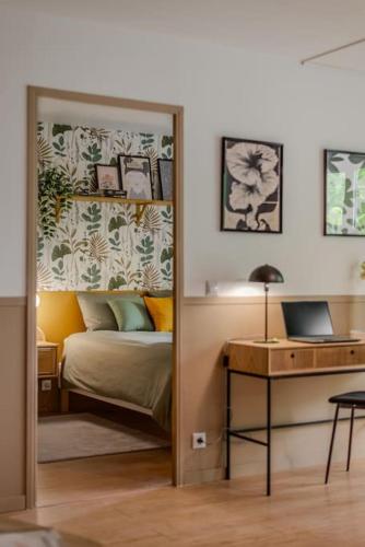 une chambre avec un lit et un bureau avec un ordinateur portable dans l'établissement Orphée by Kleidos - Disney 10min! Superbe T2, 4P, Parking gratuit, Balcon, à Magny-le-Hongre
