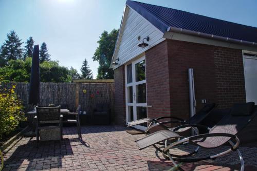 a patio with chairs and a table and a building at Emmen bed and breakfast in Emmen