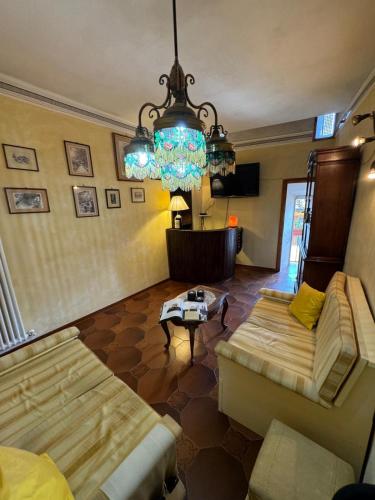 a living room with a chandelier and a couch at Micheli Suite Anfiteatro Square in Lucca