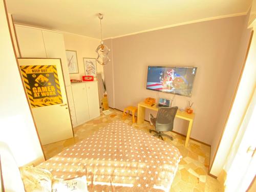 a bedroom with a bed and a tv and a desk at Milano Relax Room in Brugherio