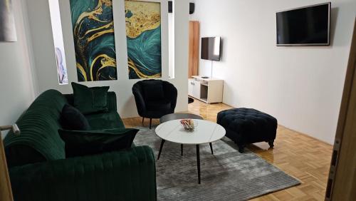 a living room with a couch and a table and chairs at Toskana Tuzla in Tuzla