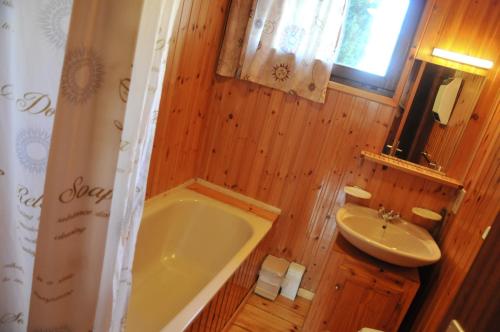 baño de madera con bañera y lavamanos en Swaens, en Heure