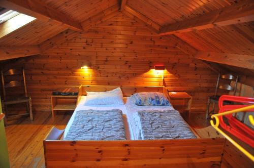 een slaapkamer met een bed in een houten kamer bij Swaens in Heure