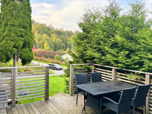 een terras met een tafel en stoelen op een dek bij Beutiful house with large garden . in Lilla Edet