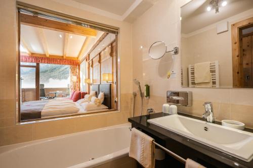 A bed or beds in a room at Alpenwellnesshotel St. Veit