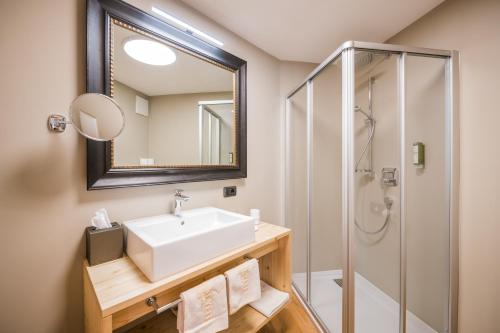 a bathroom with a sink and a shower at Alpenwellnesshotel St. Veit in Sesto
