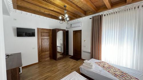 a bedroom with a bed and a wooden ceiling at Mahbubakhon Guest house in old city in Bukhara