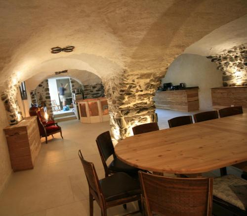 une salle à manger avec une table et des chaises en bois dans l'établissement Ecolodge La Pastoulière, à La Javie