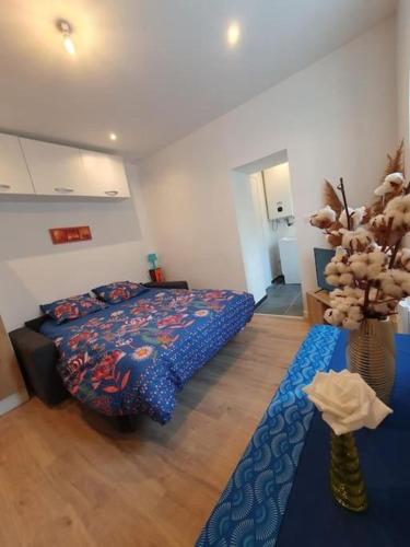 - une chambre avec un lit et un vase avec une plante dans l'établissement Appart'hôtel, IKIMO 5 appartements entiers à votre disposition au choix, à Nancy