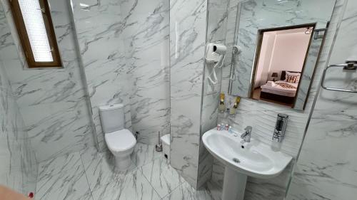a bathroom with a sink and a toilet and a mirror at Mahbubakhon Guest house in old city in Bukhara