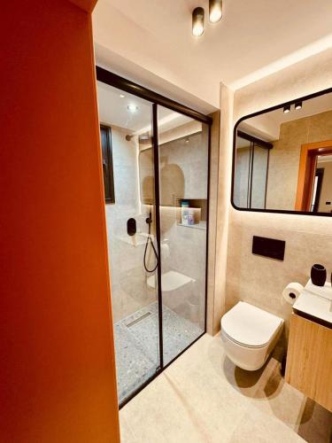a bathroom with a toilet and a glass shower at Lili's Tirana Center Apartments in Tirana