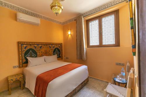 a bedroom with a large bed and a window at Dar Golden Ziat in Fès