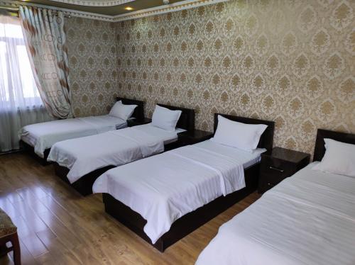 three beds in a room with a wall at Shahram Plus Boutique Hotel Registan B&B in Samarkand