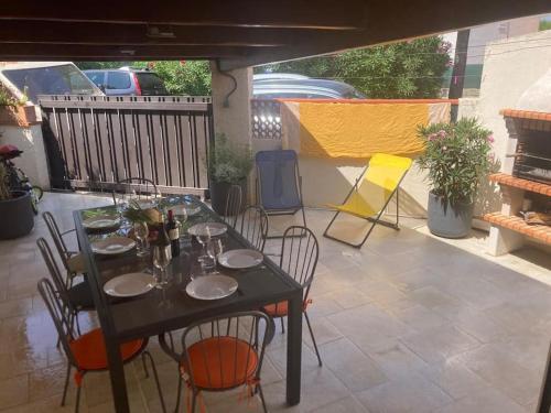 une table noire et des chaises sur une terrasse dans l'établissement Maison plage 200 mts Sainte Marie, à Sainte-Marie-Plage