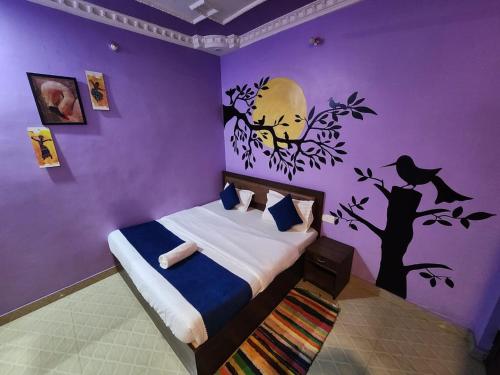 a bedroom with a bed with a purple wall at MANIK GUEST HOUSE in Rishīkesh