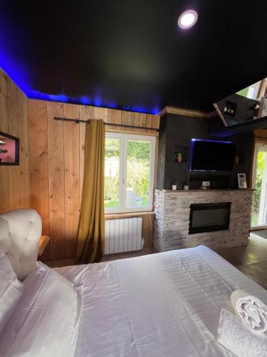 a bedroom with a large white bed and a fireplace at Le Lodge des Charmes 5 étoiles in Lèves