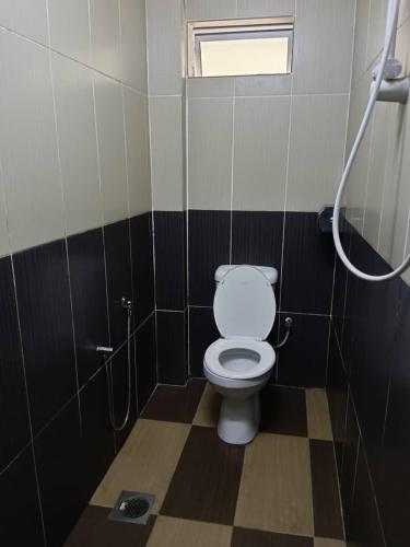 a bathroom with a white toilet in a stall at Casavilla Hotel in Taiping