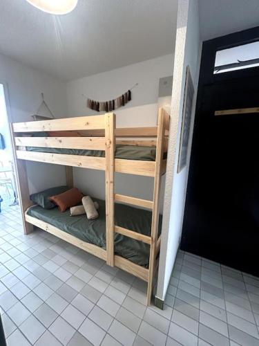 une chambre avec deux lits superposés dans une pièce dans l'établissement Le Baronnie F2 calme proche mer, au Grau-du-Roi