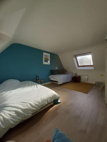 une chambre avec un lit et un mur bleu dans l'établissement Maison au calme proche de la mer Fouesnant Cap Coz, à Fouesnant