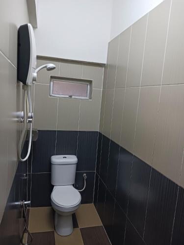 a bathroom with a toilet and a phone at Casavilla Hotel in Taiping
