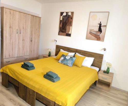 a bedroom with a yellow bed with two towels on it at Room 'Šima' with private bathroom and free air-conditioned summer kitchen in Šarića Struga