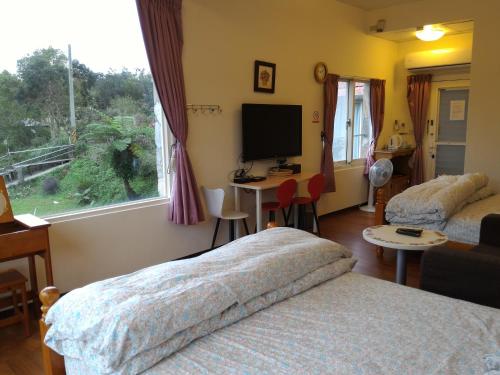 a bedroom with two beds and a tv and a window at Liang Chen Mei Jin B&B in Shuangxi
