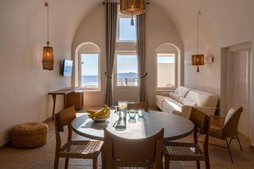 a living room with a table and chairs and a couch at La Maltese Estate in Imerovigli