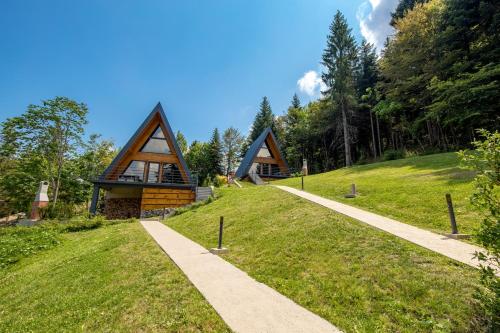 two houses on a grassy hill with a pathway at Gorska bajka - Tisa, planinska kuća za odmor i wellness in Stara Sušica