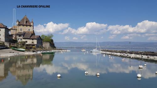 a large body of water with boats and a building at Opaline Yvoire Terrasse avec vue sur le Lac Léman in Yvoire