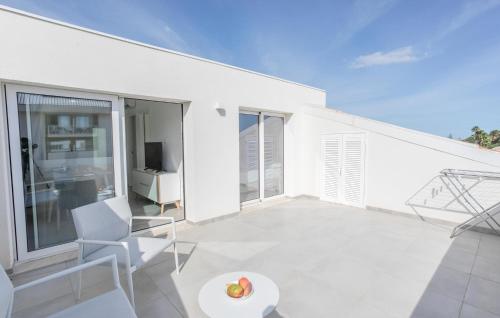 Dieses weiße Haus verfügt über einen Balkon mit einem Tisch und Stühlen. in der Unterkunft Amazing Apartment In Marina Di Modica in Marina di Modica