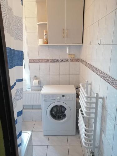 a small bathroom with a washing machine in it at Apartament z 3 sypialniami - bezpłatny parking in Łódź