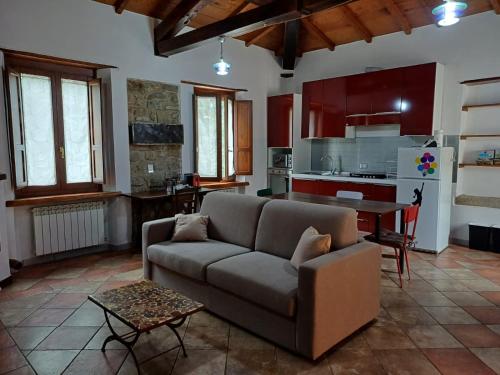 a living room with a couch and a kitchen at La Casetta di Noah in Pratovecchio