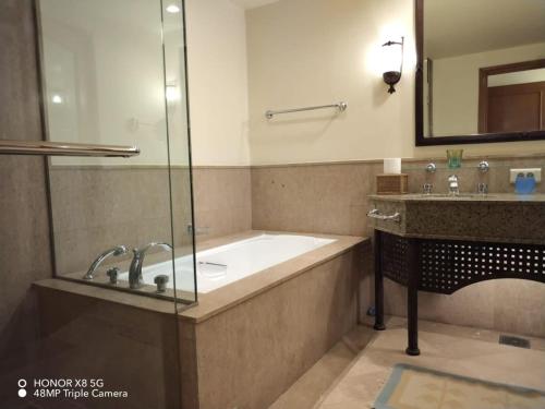 a bathroom with a bath tub and a sink at Yamour Royal Suite in Four Seasons Resort Sharm EL Sheikh in Sharm El Sheikh
