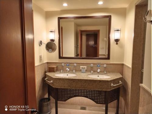 a bathroom with two sinks and a large mirror at Yamour Royal Suite in Four Seasons Resort Sharm EL Sheikh in Sharm El Sheikh