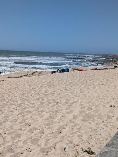a sandy beach with the ocean in the background at Guest House da Mata2 in Póvoa de Varzim