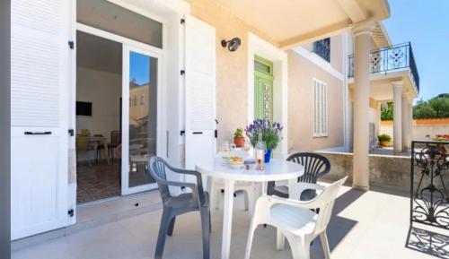un patio avec une table et des chaises blanches sur un balcon dans l'établissement Remarquable T2 avec terrasse, à Carqueiranne