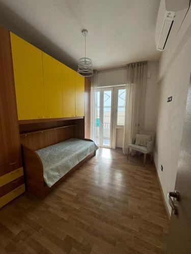 a bedroom with a bed and a yellow wall at Punto Zero in San Giovanni Valdarno