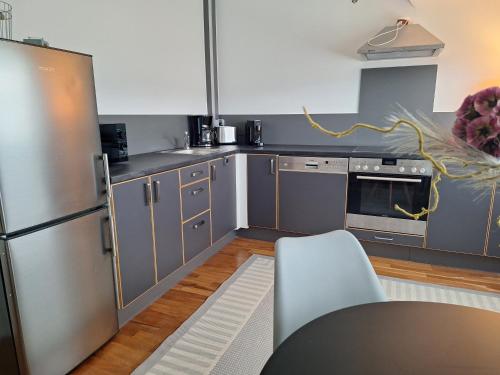a kitchen with stainless steel appliances and gray cabinets at Kleines Domizil am Südhang in Ortenberg