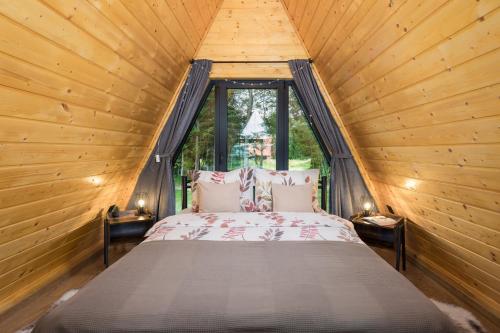 a bed in a wooden room with a window at Gorska bajka - Borovica, planinska kuća za odmor i wellness in Stara Sušica