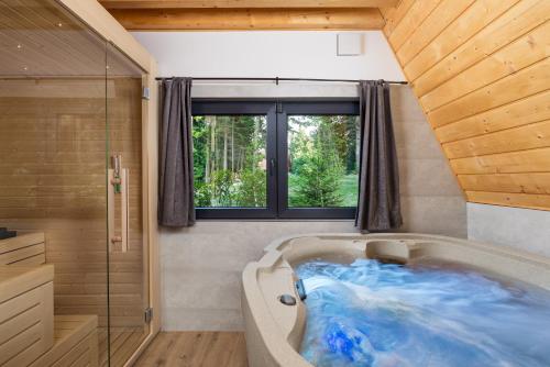 a large tub in a bathroom with a window at Gorska bajka - Borovica, planinska kuća za odmor i wellness in Stara Sušica