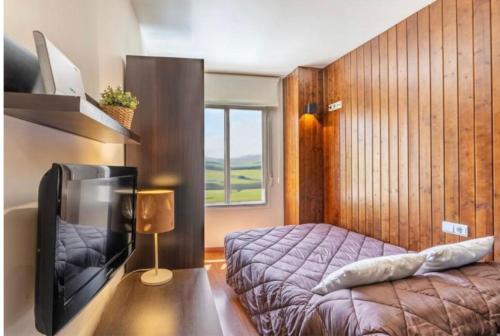 a bedroom with a bed and a tv in a room at Rural-ya Alojamientos Granada Nevada home in La Zubia