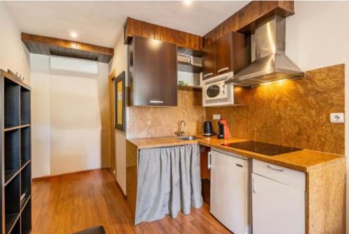 cocina con suelo de madera y electrodomésticos de acero inoxidable en Ruralya Herreria home, en La Zubia