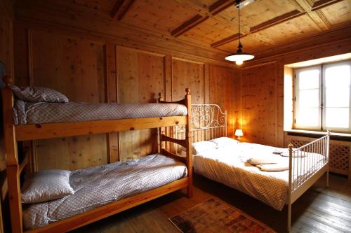 a bedroom with two bunk beds in a cabin at NIDO SUL CERMIS Affittacamere in Varena