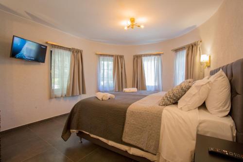 a bedroom with a bed with a tv on the wall at Berat River House Boutique Hotel in Berat