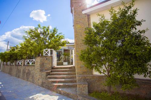 a brick building with stairs and trees in front of it at Berat River House Boutique Hotel in Berat