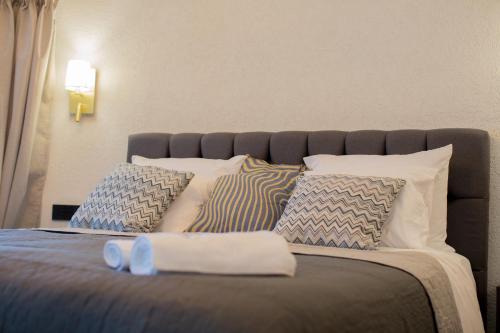 a bed with blue and white pillows on it at Berat River House Boutique Hotel in Berat