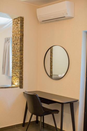 a table and a chair in a room with a mirror at Berat River House Boutique Hotel in Berat