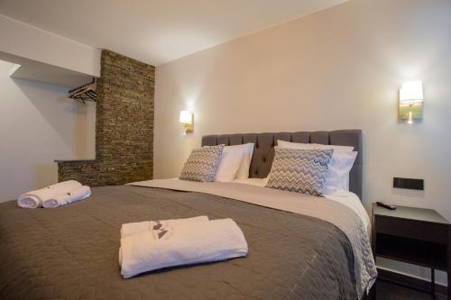 a bedroom with a large bed with towels on it at Berat River House Boutique Hotel in Berat