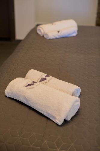 two white towels are sitting on a bed at Berat River House Boutique Hotel in Berat